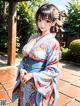 A woman in a blue kimono posing for a picture.