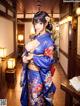 A woman in a blue kimono standing in a room.