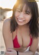 A woman in a red bikini smiling at the camera.