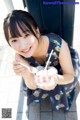 A woman holding a bowl of ice cream with a spoon.