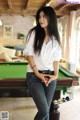 A woman standing next to a pool table in a room.