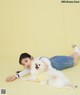 A woman laying on the ground with a white dog.