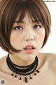 A close up of a woman wearing a black necklace.