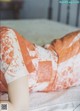 A woman laying on top of a bed covered in a blanket.