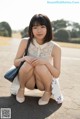 A woman sitting on the ground with her legs crossed.