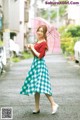 A woman walking down a street holding an umbrella.